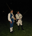 A couple minutemen standing on the green in the pre-dawn.