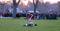 A Redcoat pokes a fallen minuteman with his musket butt on the way back to reform.